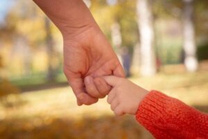 Adaptacja w przedszkolu – nauczycielka kuca na poziomie oczu dziecka pierwszego dnia